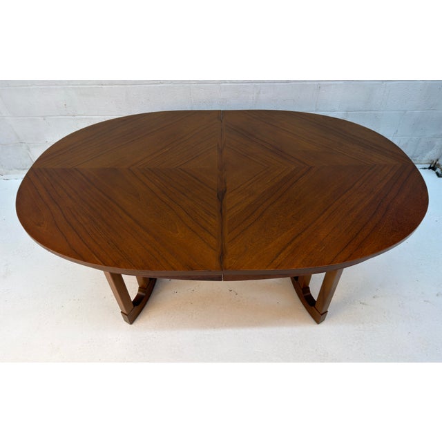 Elegant Mid-Century Modern oval dining table by Stanley, featuring a beautifully figured walnut top and a clean,...