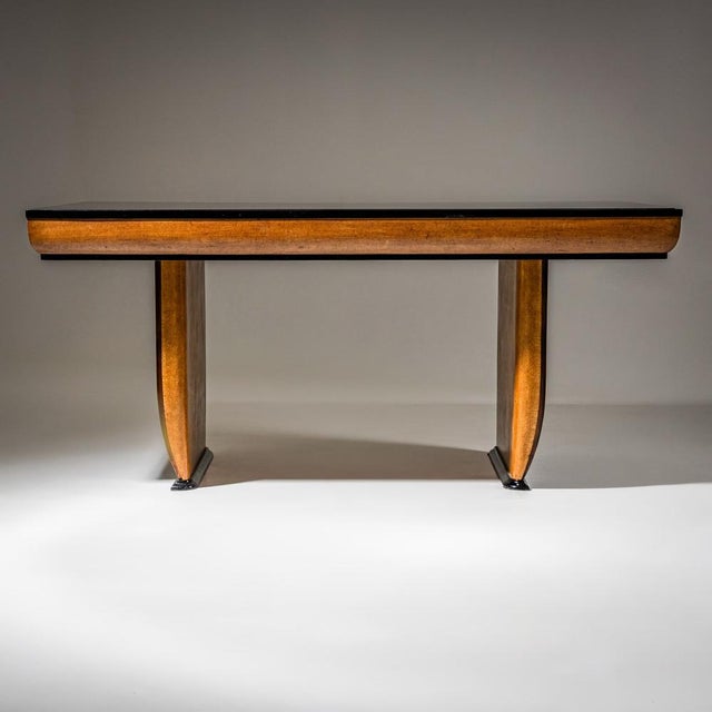 Rectangular Art Deco dining table featuring distinctive structural side panels and an inset black glass top. The legs and...