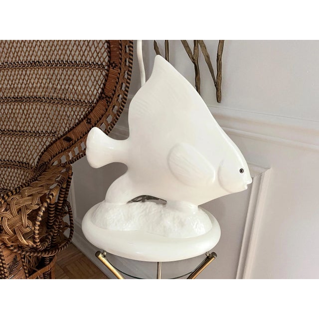Big beautiful 1970s glazed ceramic Angel fish lamp in creamy white with lifelike fins, eyes, and tail on a raised bed...