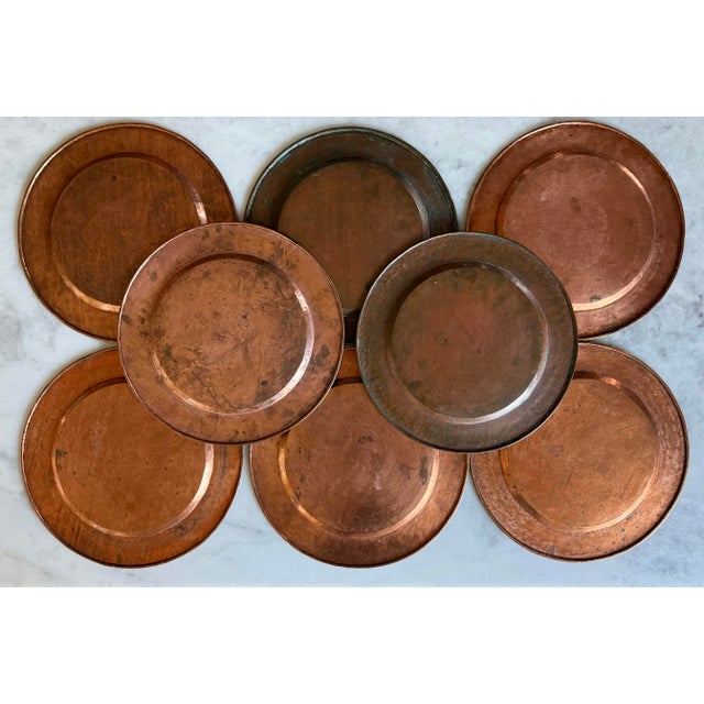 Set of 8 vintage hand made and hand hammered copper charger plates or decorative underplates with rolled edges. Varying...