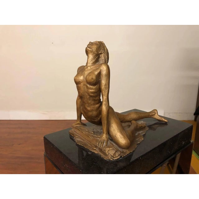 Female nude sculpture on a mirrored pedestal base. The resin sculpture is signed and dated '79. It sits on a piece of dark...