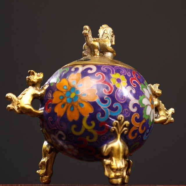 This is a cast bronze cloisonné enamel incense burner (censer) featuring a vibrant purple ground decorated with scrolling...