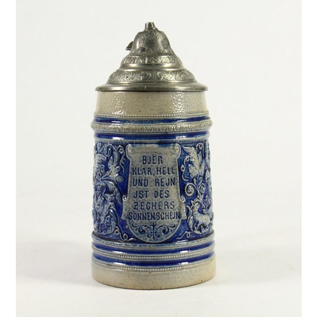 An impressive lidded beer stein/tankard Salt glaze stoneware with birds, a fox and a dog in movement, among foliate cobalt...
