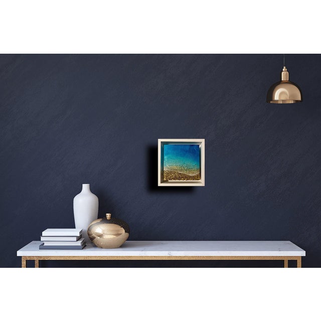 This mixed media piece on wood panel captures the serene beauty of a shoreline, where rich textures evoke the movement of...