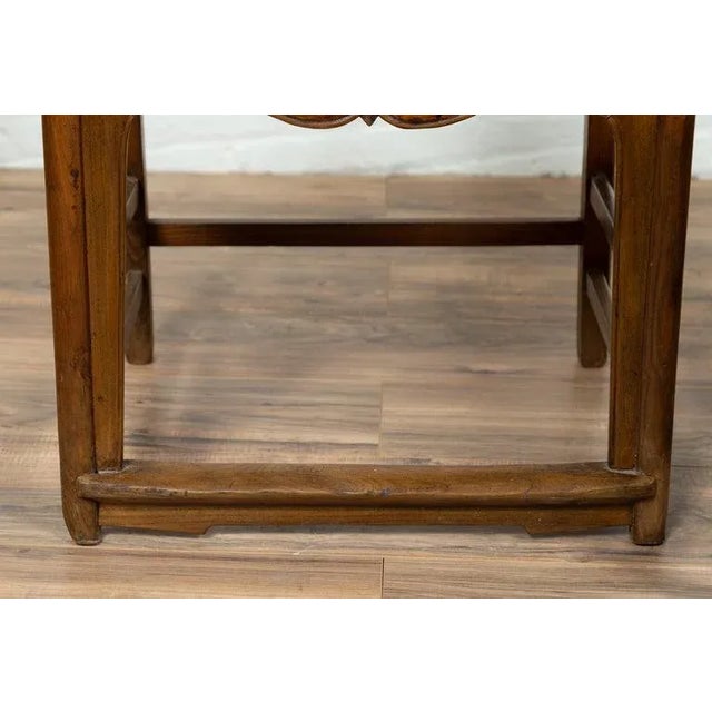 A pair of Chinese Ming Dynasty style elm scholar's chairs from the early 20th century, with unusual upper rail, carved...