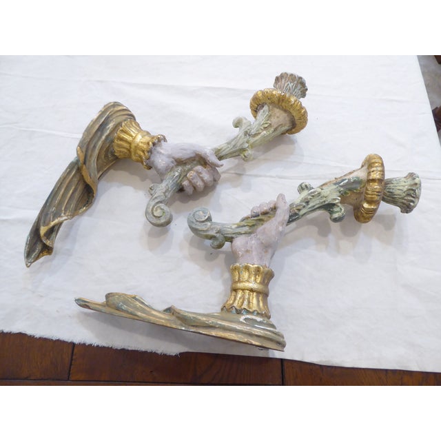 This pair of carved wood sconces with a weathered paint finish and some gilding, use standard size candles. They measure...