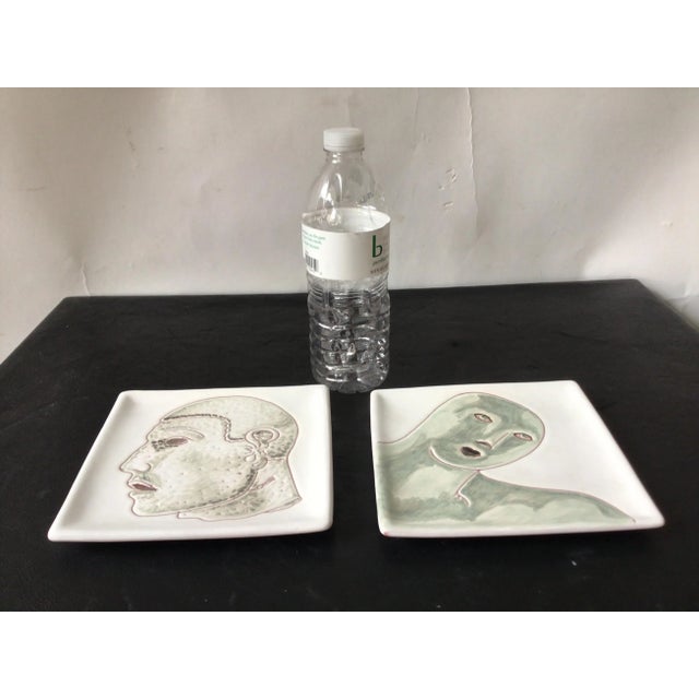 Pair of Italian ceramic plates with painted men.