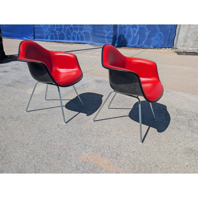 We currently have 2 red Eames Herman Miller Padded arm shell chairs. Vibrant original red Naugahyde upholstery! Date...