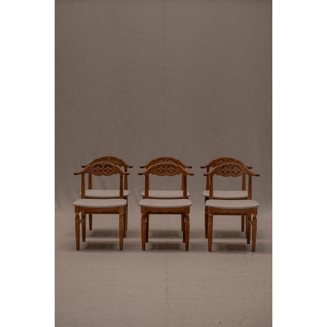 Vintage dining chair set designed by Henning Kjærnulf, Denmark 1960s. This set of six oak chairs have a curved backrest...