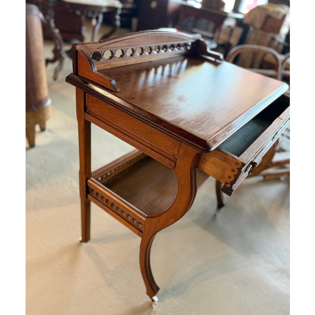 Antique solid walnut writing desk or occasional table on casters in the Eastlake style with a single drawer and two...