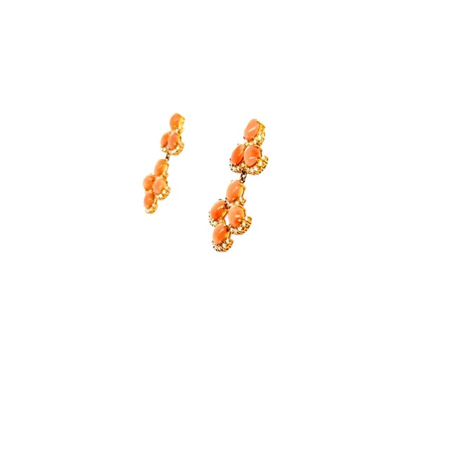 These fun earrings contain 14 oval cabochon coral and 84 round brilliant cut diamonds weighing approximately 2.25 carats...