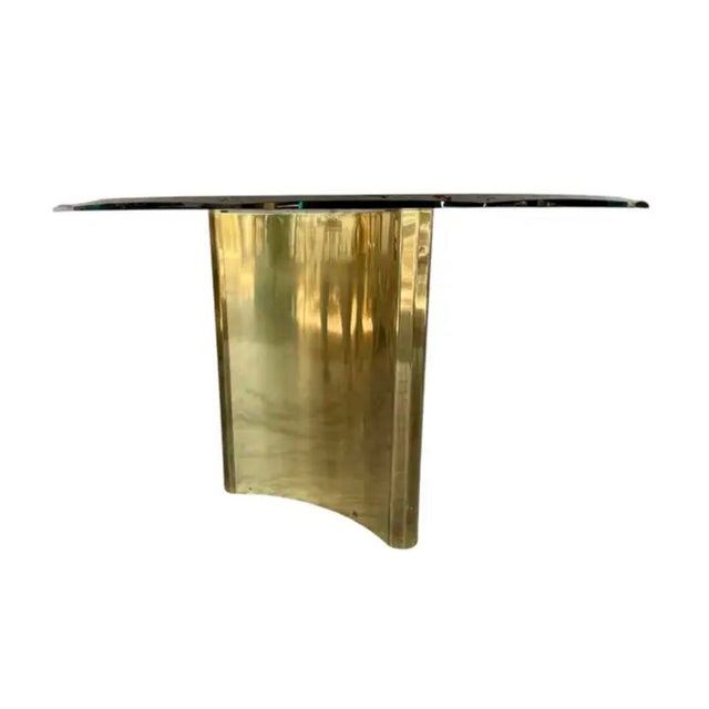 Vintage Mastercraft "Trilobi" Table features thick beveled glass top resting on a brass sculptural pedestal base. The...