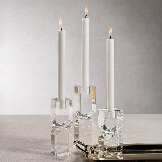 Illuminate your space with style and grace. Our crystal glass taper candle holder with a square column shape and sleek...