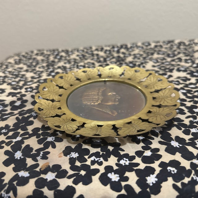 This vintage item is a decorative wall plaque featuring a striking, ornate brass frame with a detailed butterfly motif...