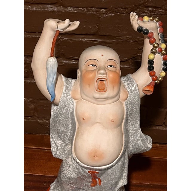 This striking vintage 20-inch Chinese porcelain figure depicts a joyful Budai (Laughing Buddha) in a stretching pose with...