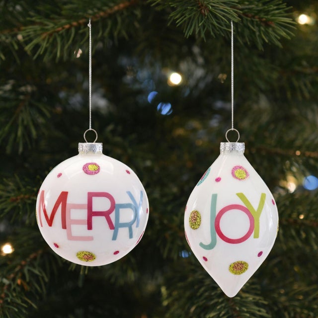 Celebrate the season with style using this set of Glass Merry and Joy Ornaments. Each ornament features cheerful Merry...