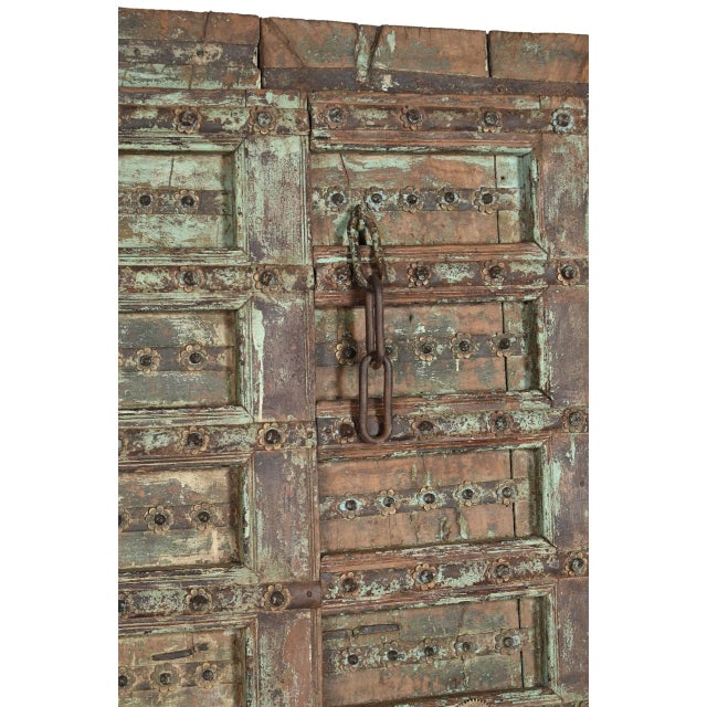Antique Indian Carved and Painted Teakwood Gujarati Door, each door panel with 8 panels, centered with an iron strap with...