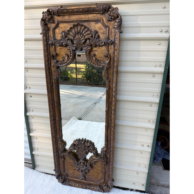 Beautiful La Barge floor mirror in an Italian Rococo Revival style. Features a carved frame with a warm burnished honey...