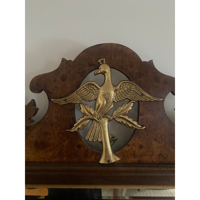 Vintage Hepplewhite mirror in elm burl veneer with brass ornament. Beveled glass surrounded by thin gold frame. Overall...