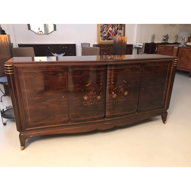 Stunning French Art Deco four-door sideboard in the style of Jules Leleu. With beautiful rosewood and mother-of-pearl...