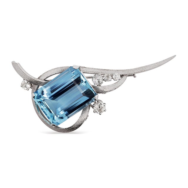 Brushed finish 14K white gold retro-era brooch centers a 39.20 carat emerald cut aquamarine within an openwork wing and...