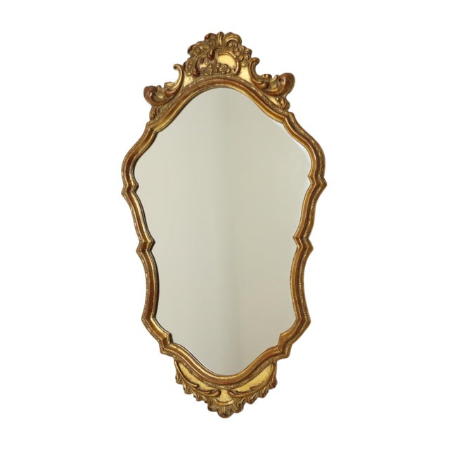 Mid-century Deknudt mirror in a classic wooden frame gilded with gold leaf, entirely in Baroque style; the design is...
