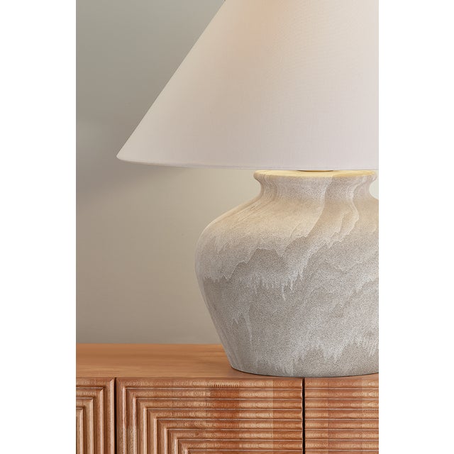 The Allards table lamp draws inspiration from traditional pottery and the beauty of artisan glazing. Its ceramic, urn-like...