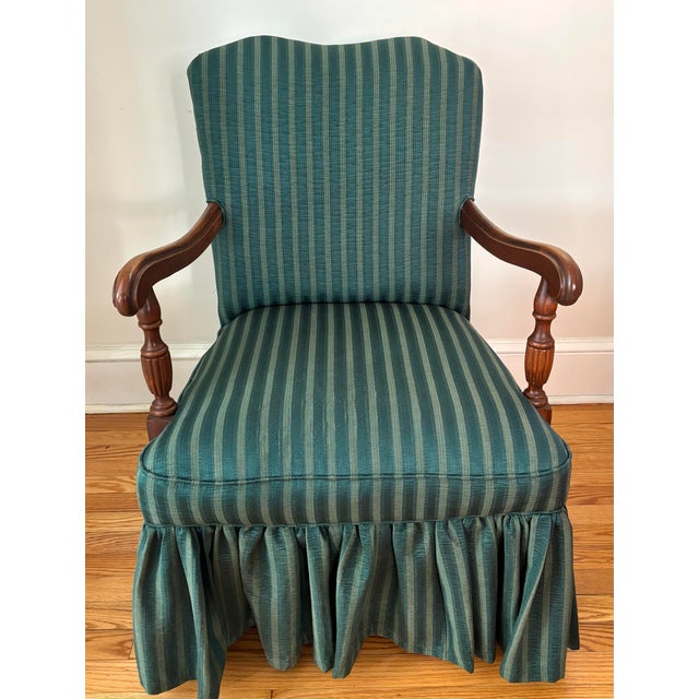 Regency style carved mahogany armchair upholstered and skirted in a dark forest green striped upholstery fabric. Solid and...
