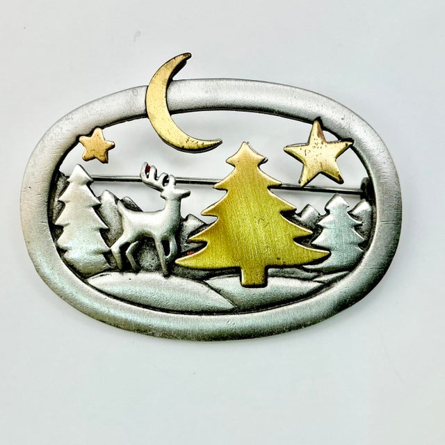 A lovely Christmas Brooch from Janette Jewelry out of Rhode Island from the 1980s. It features a silver metal oval with...