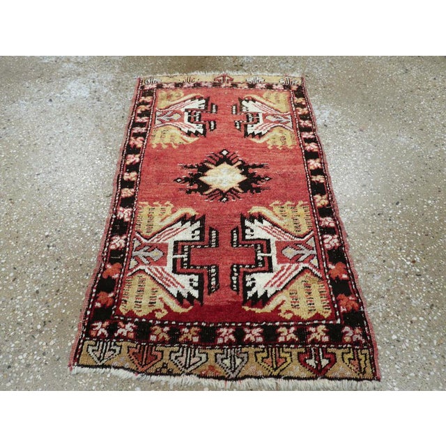 This Mid-20th century Turkish Oushak rug, measuring 1' 7" x 2' 9", is a striking example of the bold, geometric artistry...