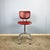 Iconic swivel chair with a uniquely shaped chrome frame, the typical encapsulated casters, and a marbled, burgundy faux...