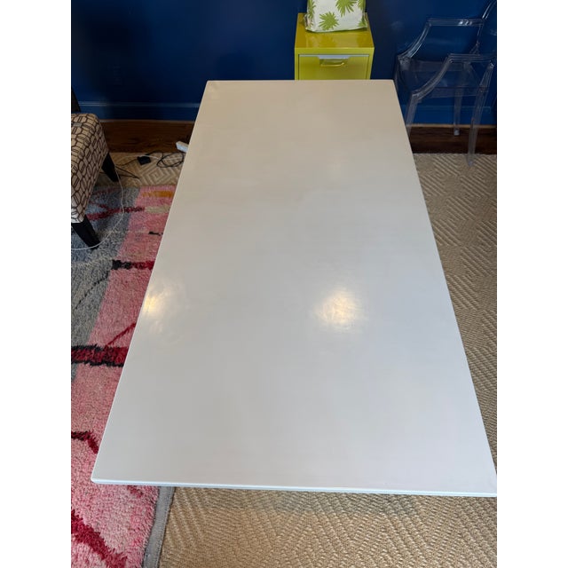 Simple trestle table made interesting with a white lacquered finish. Table has some dings and scratches from years of...