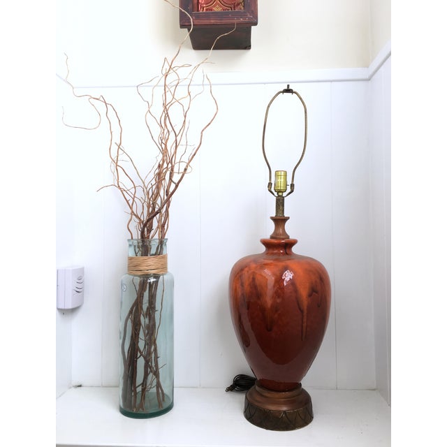 This striking mid-century drip glaze ceramic table lamp features a rich blend of amber, chestnut, and golden brown hues...