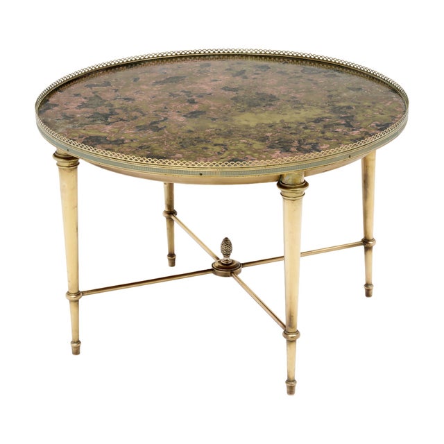 French gilt brass side table from the Art Deco period. The table has four tapered legs connected with an x-stretcher...