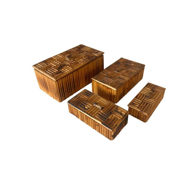 A graduated set of four vintage bamboo boxes, each lid finished in a scorched parquet basket-weave pattern topped with a...