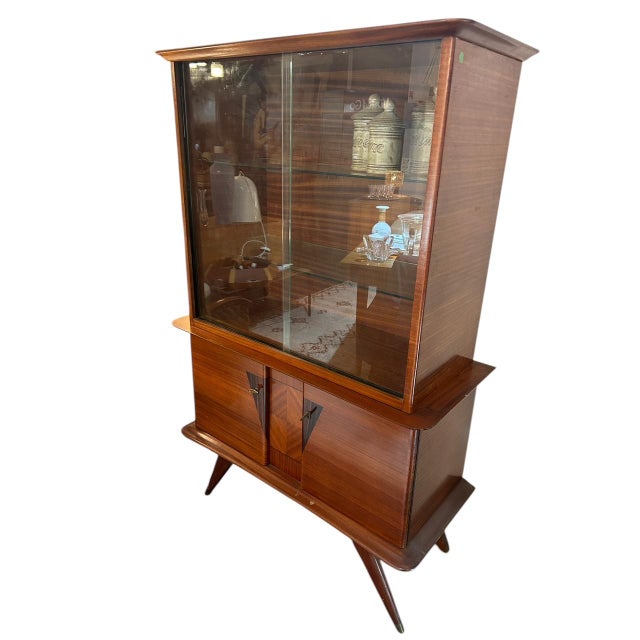 An elegant display cabinet from the mid-20th century (1950s), most likely of Italian origin. This piece features a refined...