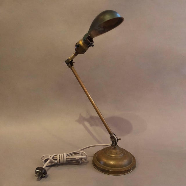 Industrial, desk lamp by Faries features an adjustable painted steel pea shade with articulating brass body and graduated...