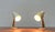 Small mid-century French table lamps. An elegant design in white and brass with colored accents. The lamps consist of a...
