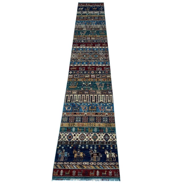 A nearly sixteen-foot runner in the Qashqai pictorial khorjin (saddlebag) design of southern Persia, hand-knotted in...