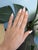 A natural purple spinel from Madagascar takes center stage in this round ring, encircled by sparkling diamonds in solid...