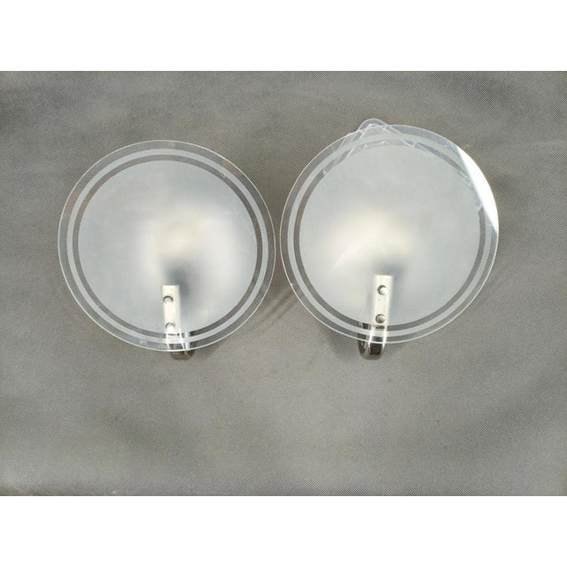 Elegant pair of art deco wall lights produced in czechoslovakia during the 1940s featuring circular frosted glass shades...