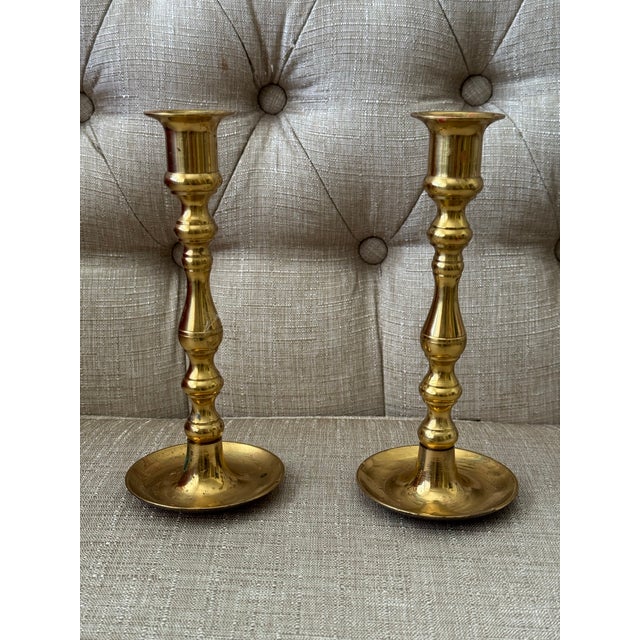 Pair of vintage brass candlestick with a classic turned design and warm golden patina. Each candlestick features a wide,...