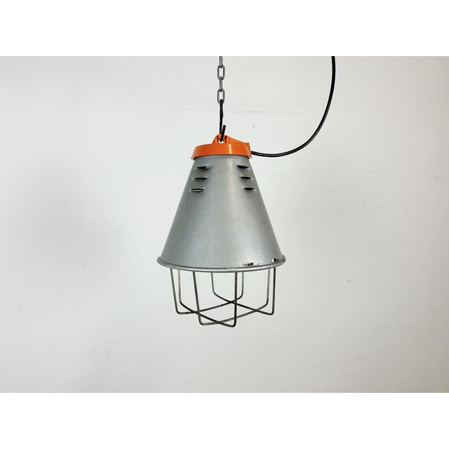 Industrial factory hanging lamp made by Polam Wilkasy in Poland during the 1970s. It features a grey hammerpaint aluminium...