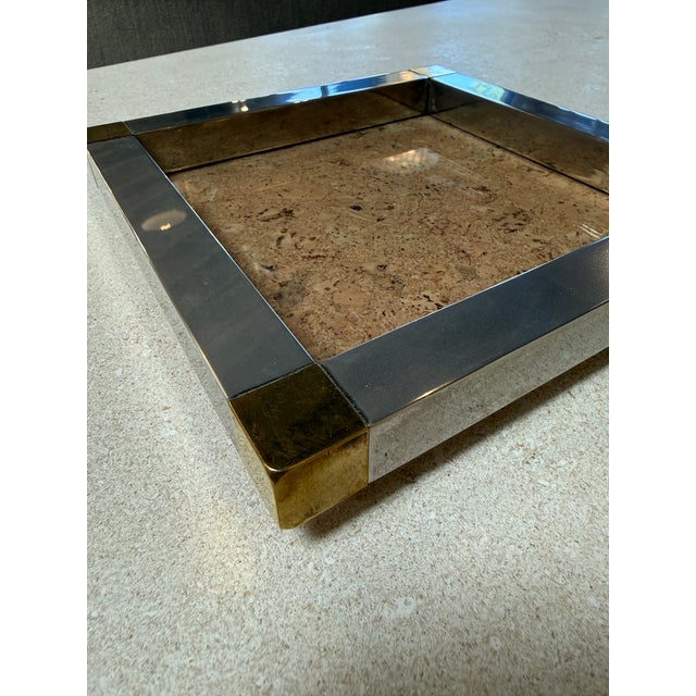 Stylish vintage tray featuring a natural cork surface framed by brushed metal sides and accented with polished brass...