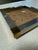 Stylish vintage tray featuring a natural cork surface framed by brushed metal sides and accented with polished brass...