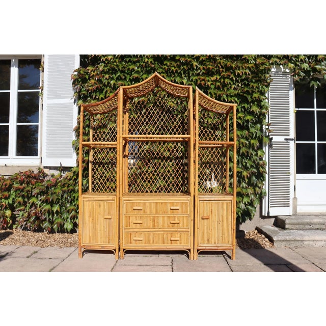 Large rattan shelf decorated with an Asian-style pagoda. 1970s period. from Italy. Three-part shelf. Equipped with three...