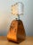 This vintage table lamp pairs a sculptural stirrup-form wood base with metal hardware, reflecting the organic, hand-...
