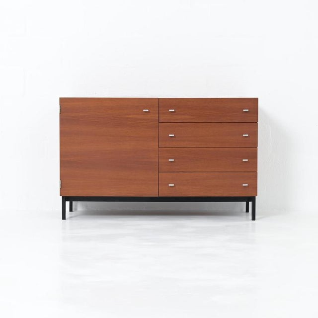 A timeless 1960s cabinet by Pierre Guariche for Meurop, featuring a teak veneer and metal handles. Meurop helped bring...