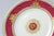 A pretty set of 16 plates with a ruby powder finished collar accented with a raised double griffin gilt motif and central...