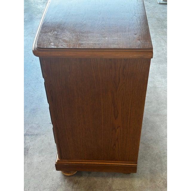A vintage Mid-Century chest of drawers in oak and oak veneer, featuring four large drawers offering ample storage. It is...